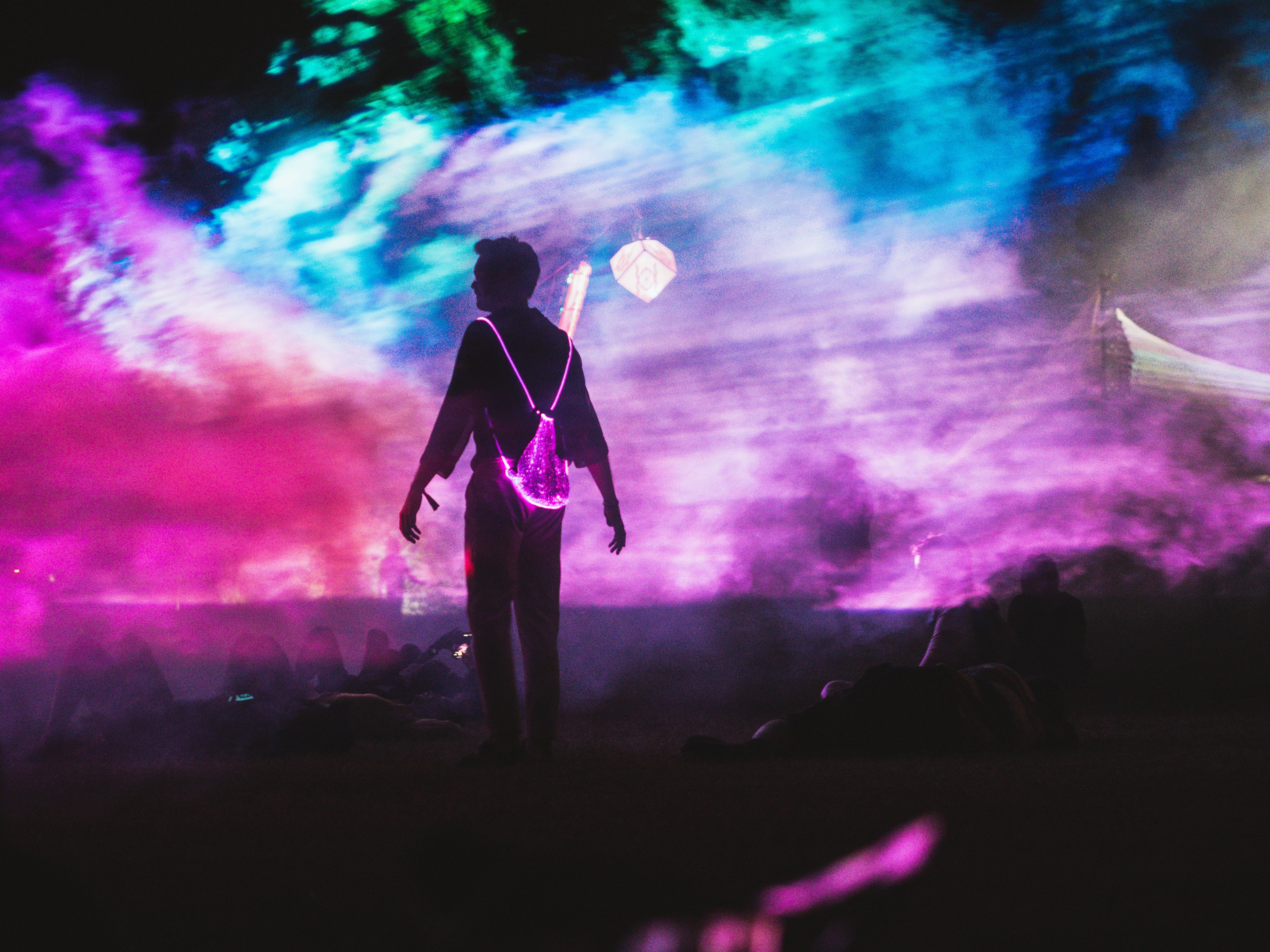 animated man wearing the drawstring backpack on a festival, with lasers in the background