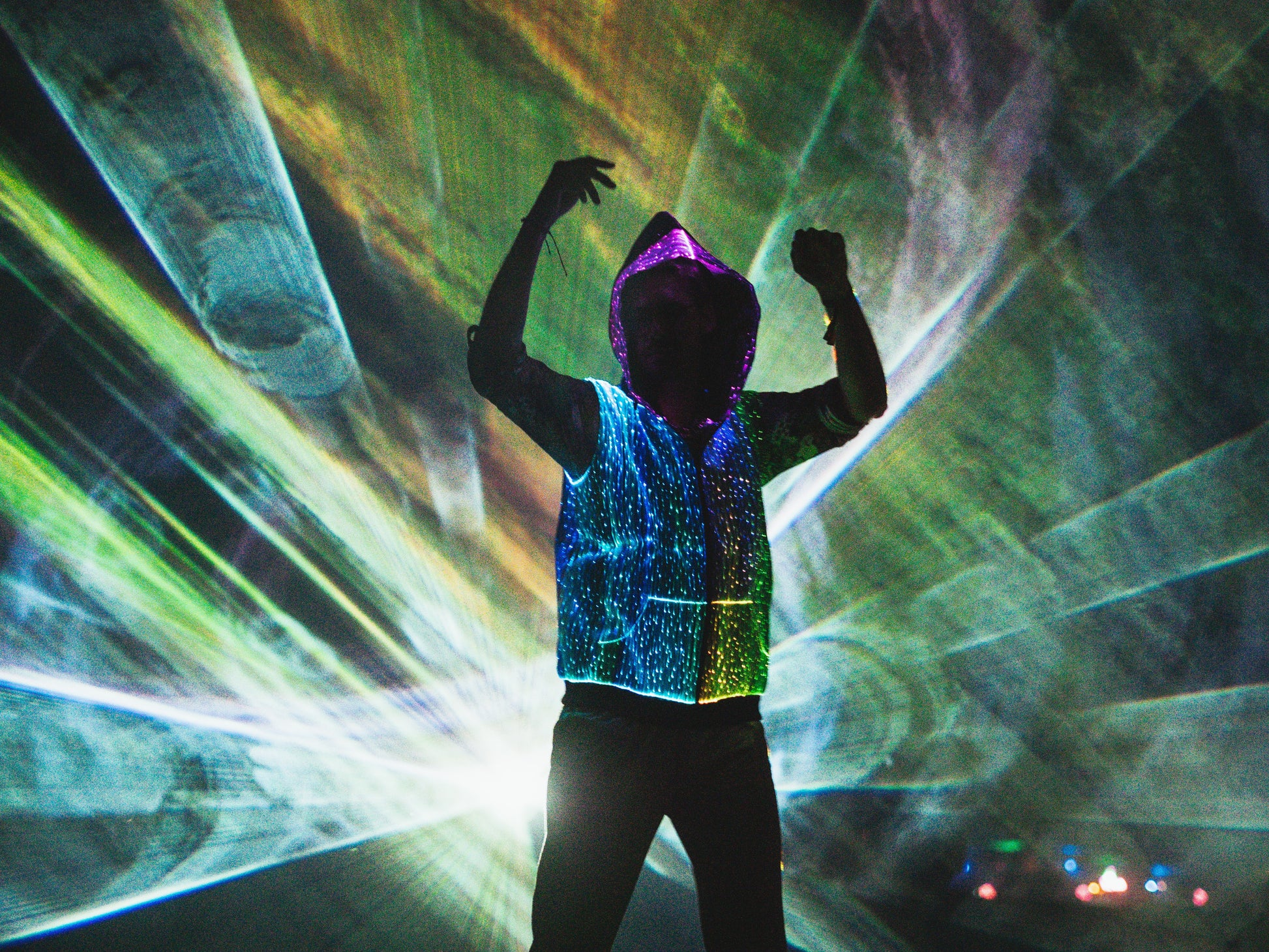 animated man wearing the NEBULITE vest on a festival, with lasers in the background