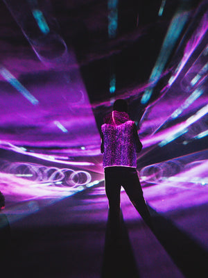 animated man wearing the NEBULITE vest on a festival, with lasers in the background