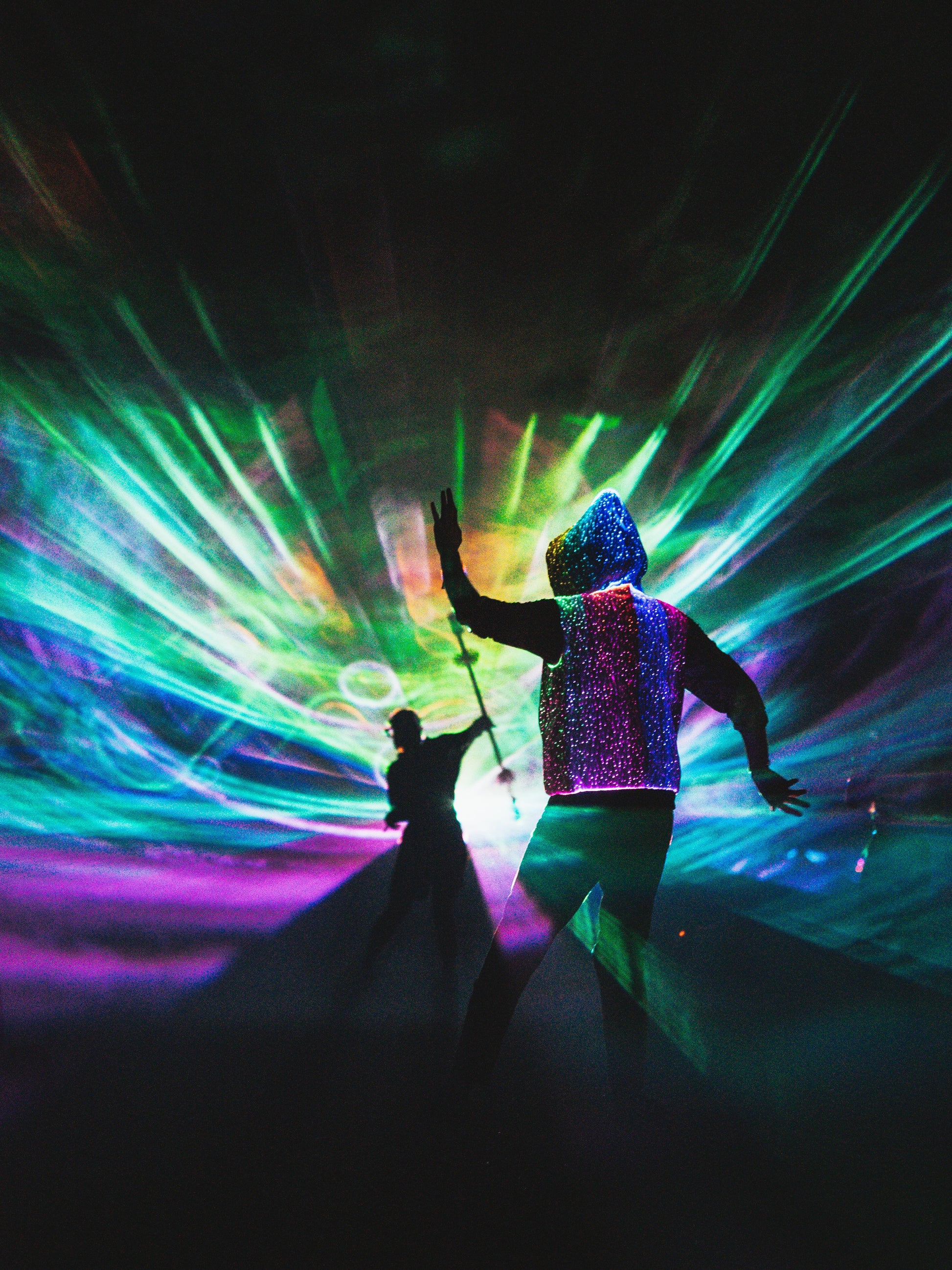 animated man wearing the NEBULITE vest on a festival, with lasers in the background